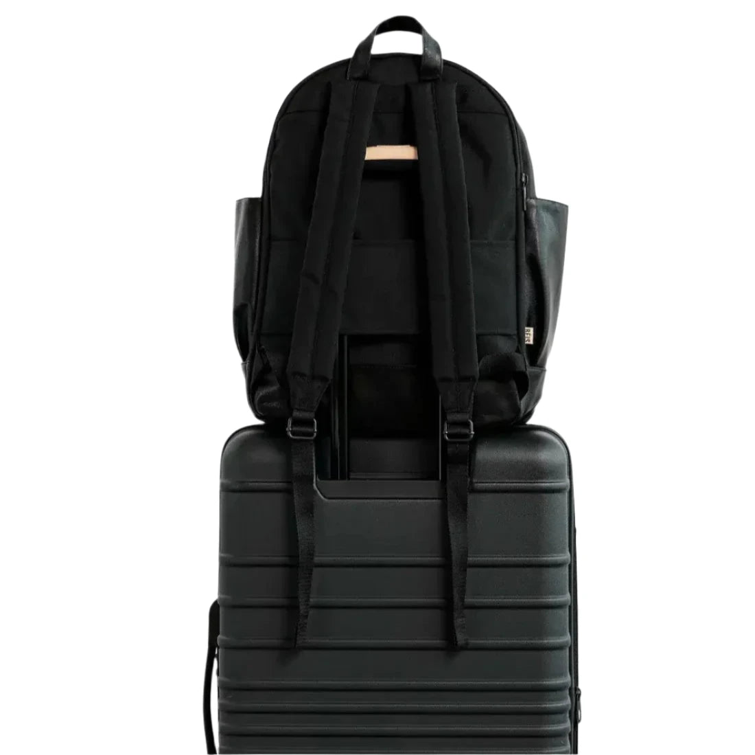 back view of black backpack on top of a piece of luggage