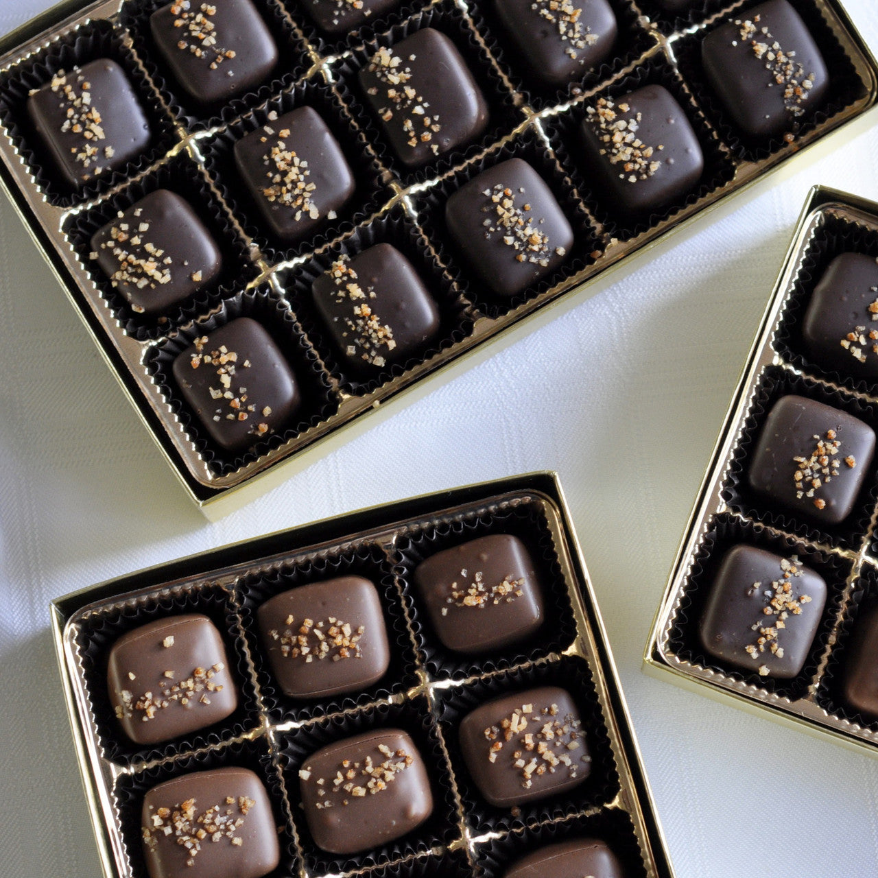 Open boxes of chocolate candies with sea salt and habanero sprinkled on top