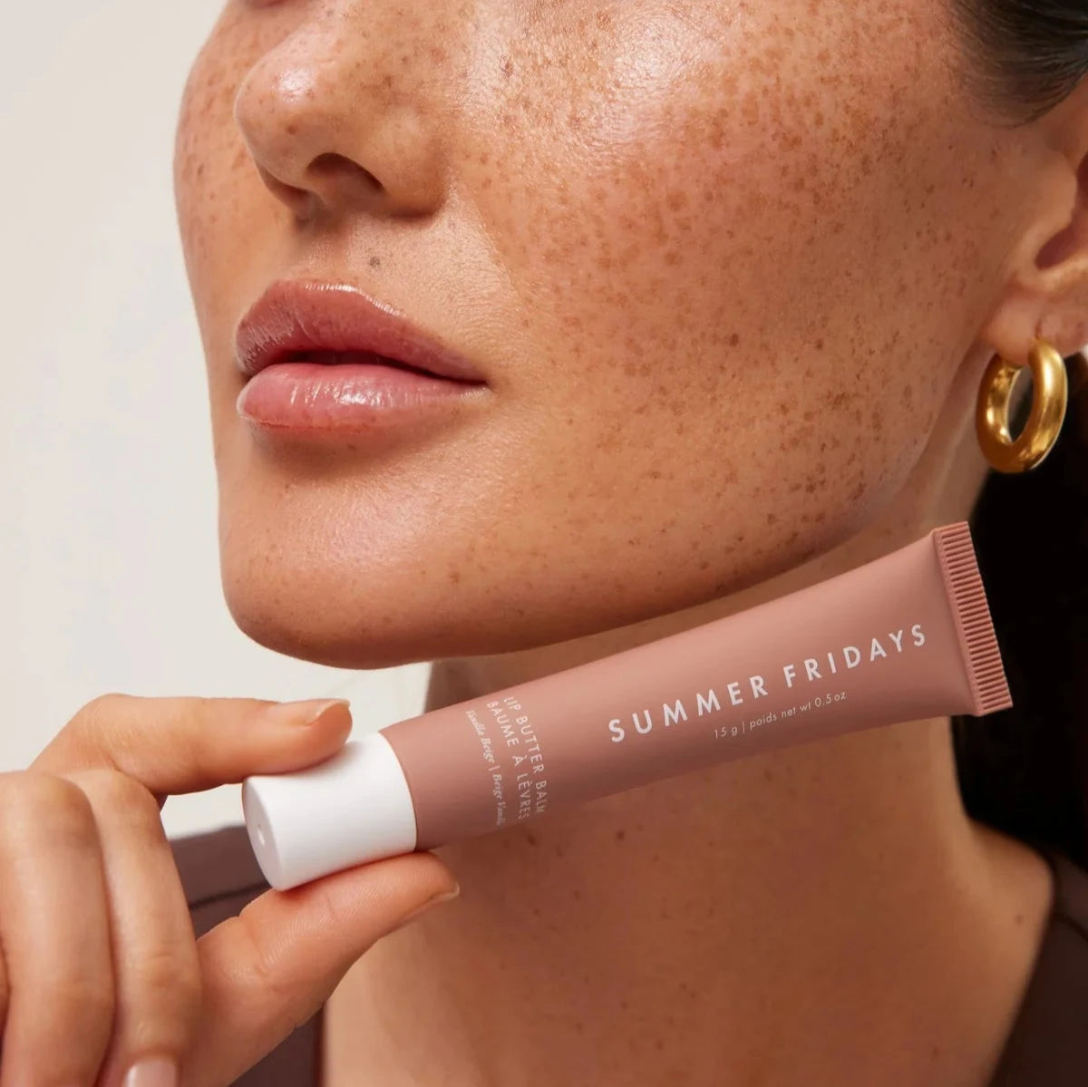 model holding lip butter balm product with moisturized lips, gift for her