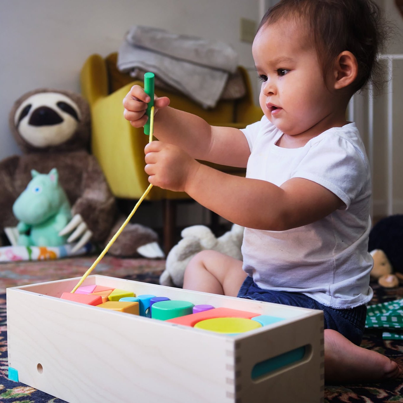 baby playing with wooden toy
