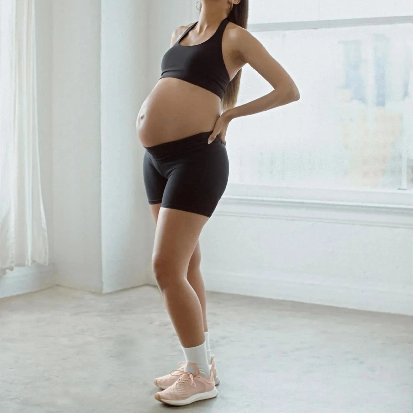 Pregnant woman wearing shorts and felix sneakers