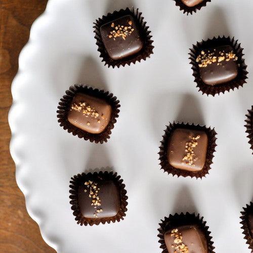 chocolate candies on a white plate with sea salt and habanero sprinkled on top