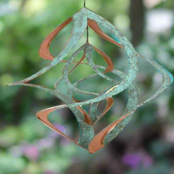 close up image of wind spinner with blurred background of garden 