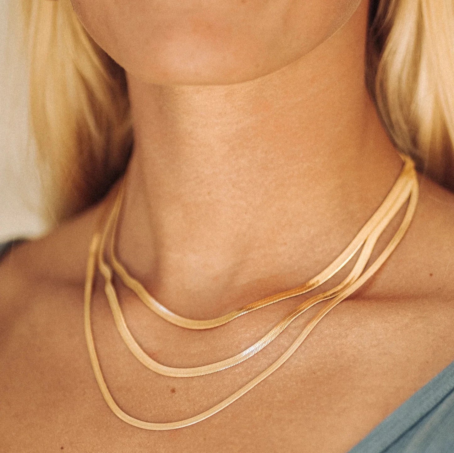 gold necklace on woman showing just neck area