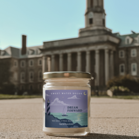 dream forward candle in front of penn state building