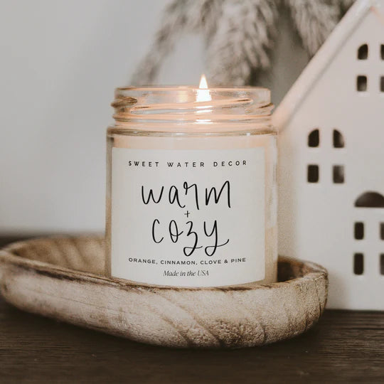 lit candle with warm and cozy label