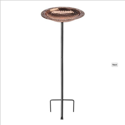 copper bird bath on top of black steel stake