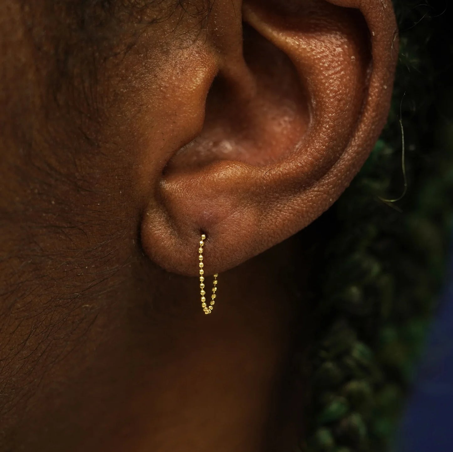 delicate earring that looks like continuous chain hoop