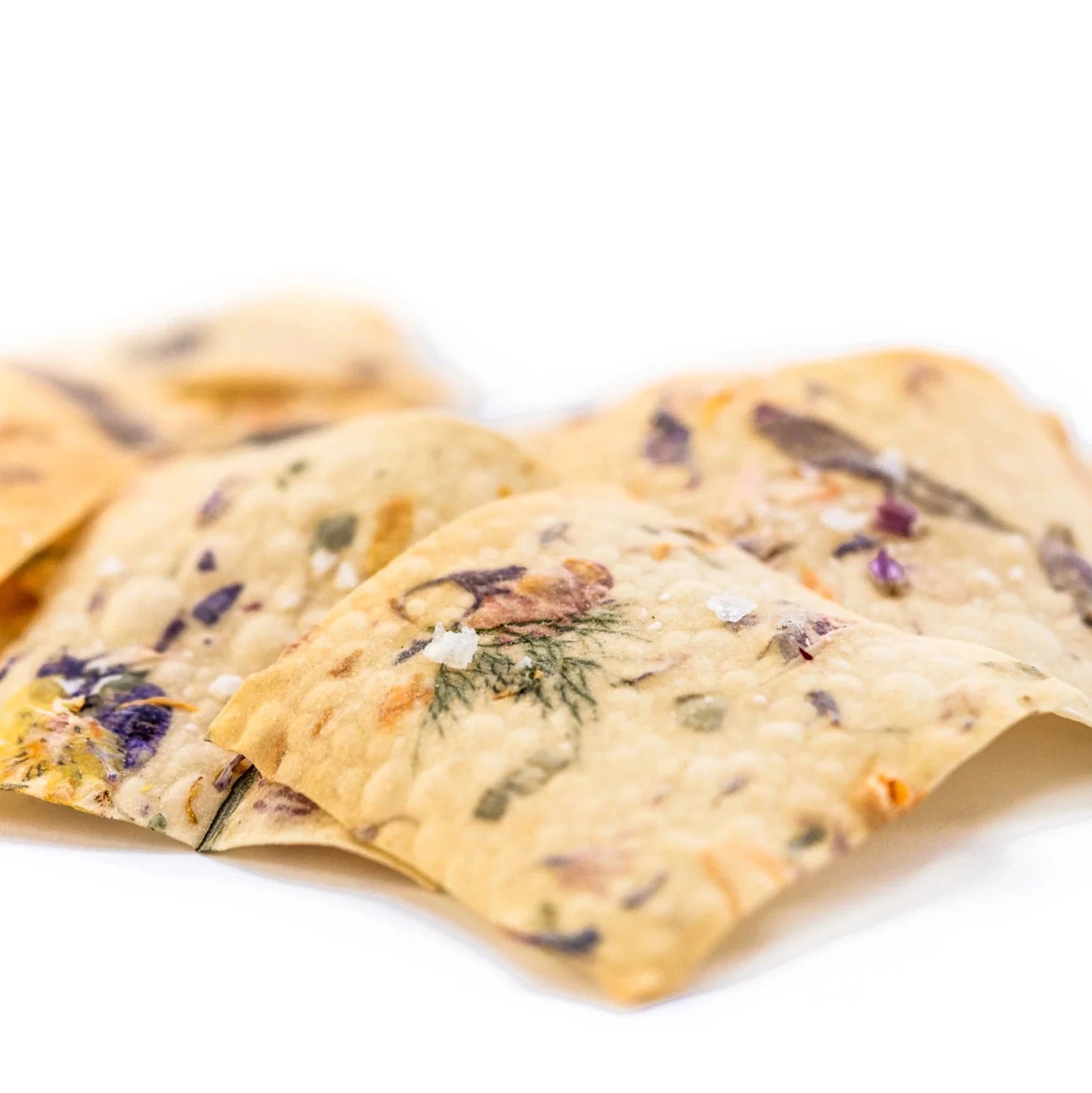 close up of crackers salted and decorated with edible flowers and herbs