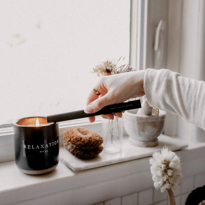 person lighting a candle with black electric candle lighter