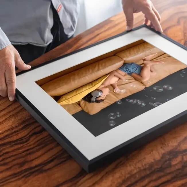 black framed photo of kid on couch