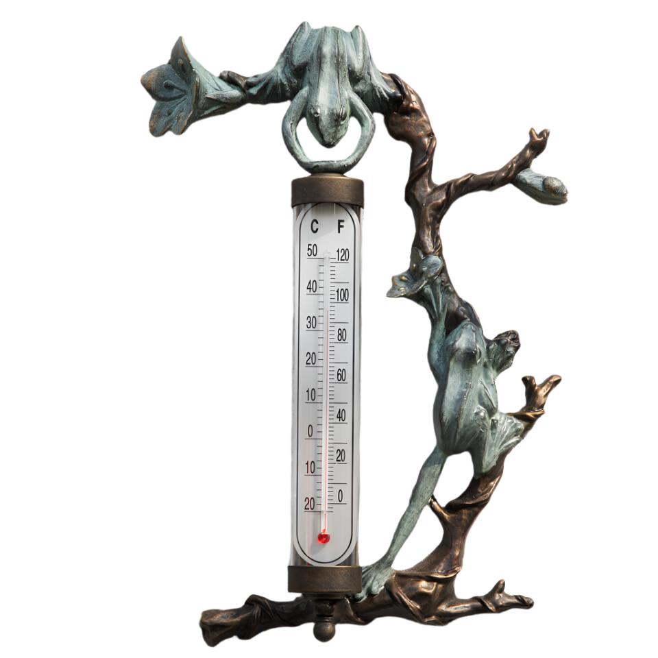 two frogs and branches around a glass thermometer