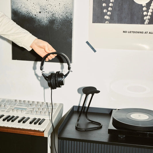 person about to place headphones on headphone stand